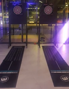Två darttavlor på ställningar med dartmattor