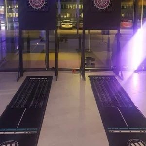 Två darttavlor på ställningar med dartmattor